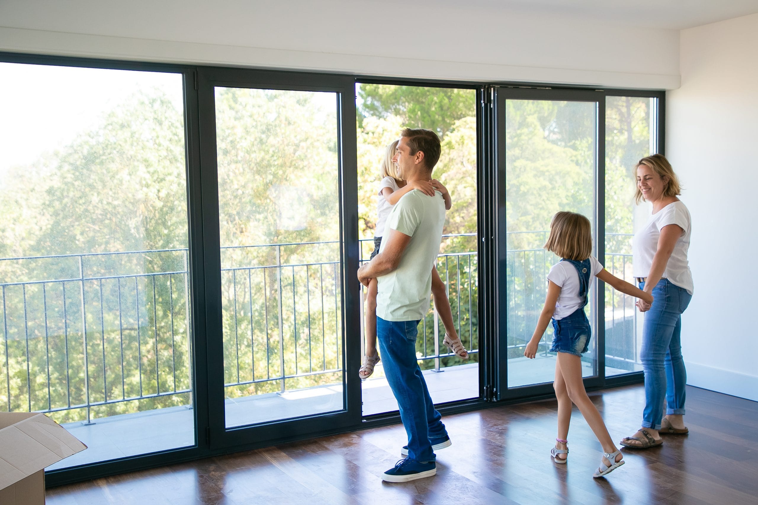 happy-father-with-daughter-standing-near-open-balcony-smiling